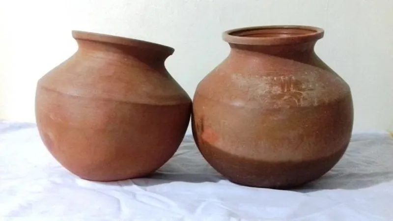 A pair of mud pots crafted from clay, known for their natural benefits like keeping water cool and enhancing food flavors, blending tradition with health.